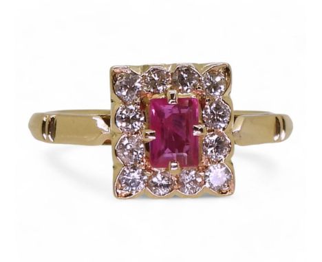 An 18ct gold ruby and diamond ring, set with a step cut ruby of approx 4.9mm x 3.4mm, surrounded with 0.25cts of brilliant cu