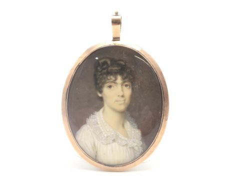A GEORGE III MOURNING PORTRAIT MINIATURE Painted on ivory, with plaited hair verso, housed in a yellow metal pendant mount en