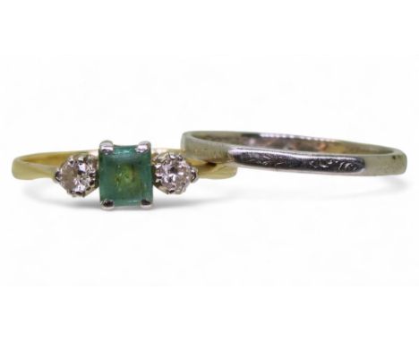 An emerald and diamond three stone ring, in bright yellow and white metal set with an (af) step cut emerald and two brilliant