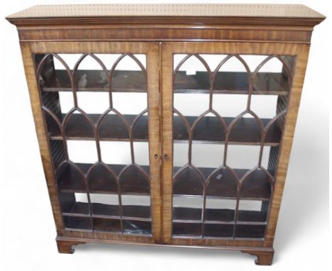 A 20th century mahogany glazed bookcase with moulded cornice over pair of glazed doors overlaid with gothic patterned bead on