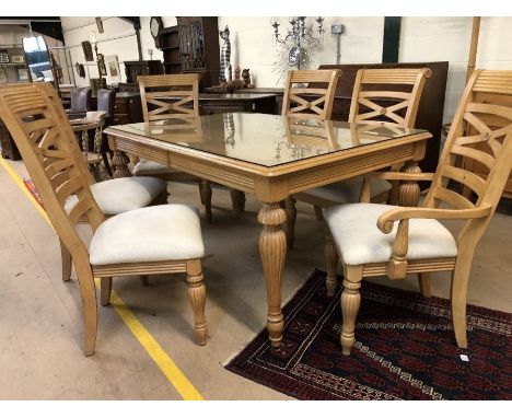 Light wood glass-topped extending dining table with carved detailing and six chairs with upholstered seats (two carvers).  Ta