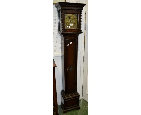 An oak grandmother clock, stepped cornice, brass dial, Roman numerals, mask spandrels, Junghans movement, the face flanked by