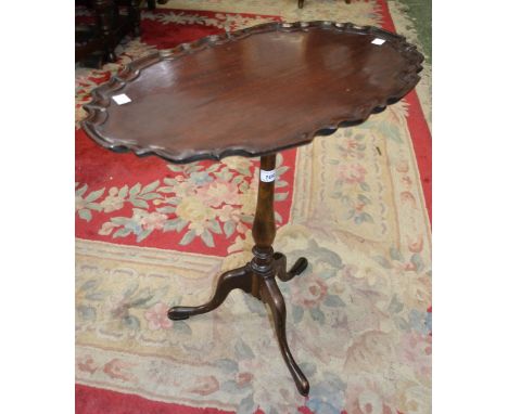 A Chippendale Revival mahogany shaped oval tilt-top tripod occasional table, piecrust edge, turned column, cabriole legs, ear