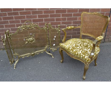 A Louis XV style gilt salon elbow chair, rattan back, padded outswept arms, padded seat, French cabriole forelegs with acanth