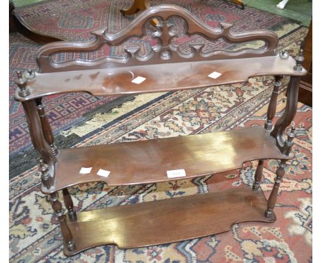 A mahogany three tier wall shelf, pierced gallery, shaped tiers, turned and finialed supports.