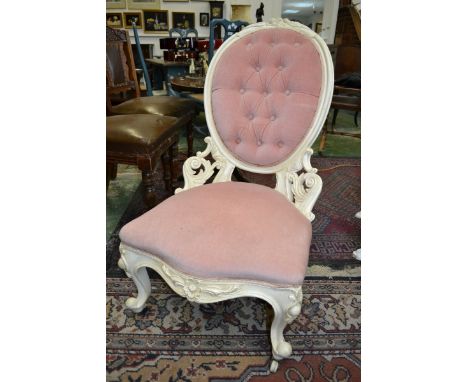 A Victorian painted mahogany nursing chair, floral cresting top rail, button upholstered oval back, stuffed overseat, cabriol