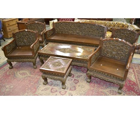 An oriental style living room suite comprising three seat sofa heavily carved flora in relief, four armchairs, coffee table a