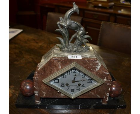 An Art Deco rouge marble clock, the navette shaped silvered dial with Arabic numerals, twin winding holes, the marble case su