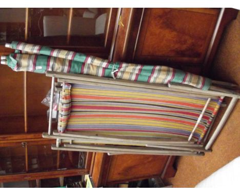 Two vintage deck chairs together with a wind screen