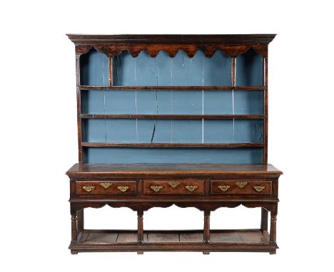An oak dresser, mid 18th century, with plate rack canopy above the dresser base, 197cm high overall, 187cm wide, 47cm deepCon