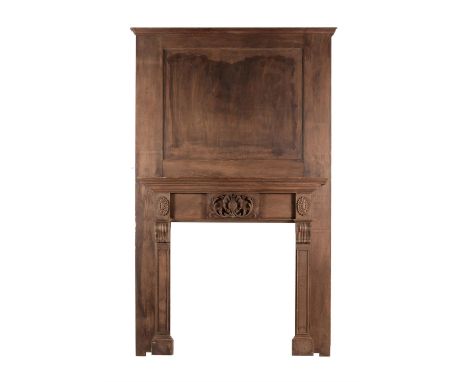 A stained pine chimneypiece in George III style, 20th century, with vacant moulded rectangular panel over the mantelpiece, th