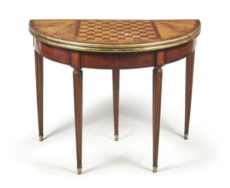 A French walnut and mahogany games table, first half 19th century, of demi-lune outline, the folding top with inlaid Continen