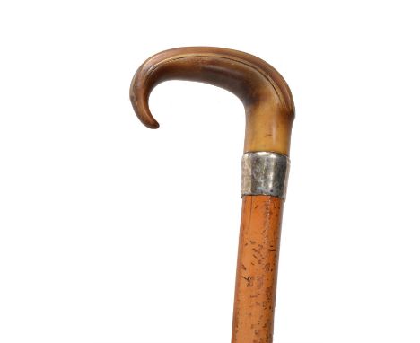 Y A Victorian rhinoceros horn and malacca walking stick, late 19th century, the shaped handle above a silver coloured metal b