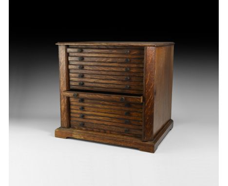 Early 20th century AD. A wooden collector's cabinet with ten velvet-lined sliding trays (31 x 29cm) each with two brass knop 