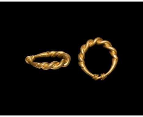 10th-12th century AD. A finger ring of tapering gold rods twisted around each other, the ends twisted round the shank.   8.55