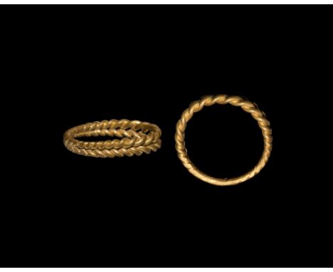 10th-12th century AD. A gold finger ring formed as two parallel twisted bands.   5.05 grams, 23mm overall, 18.90mm internal d