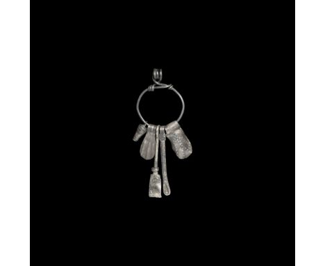 10th-12th century AD. A silver cosmetic and amuletic set including miniature situla, duck-foot amulet, tweezers, scoop and co