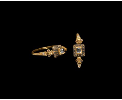 Late 16th century AD. A slender gold hoop with quatrefoil to each shoulder flanking a bezel with scooped sides, enamel lattic