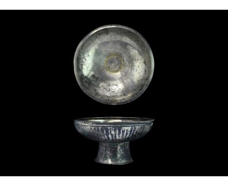 Early 1st millennium AD. A silver footed bowl with ribbed outer wall and deep chamfered rim, flared foot, parcel-gilt ring to