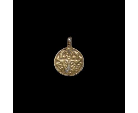 9th-10th century AD. A silver-gilt discoid pendant with pellets to the integral loop, pelletted border enclosing a low-relief