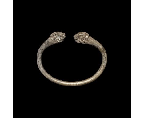 1st millennium BC. A silver penannular bangle with opposed lion-head finials.   44.7 grams, 67mm (2 3/4"). Property of a Nort