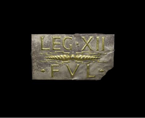 1st-2nd century AD. A silver rectangular plaque with folded edges and fixing holes, having a parcel-gilt repoussé inscription