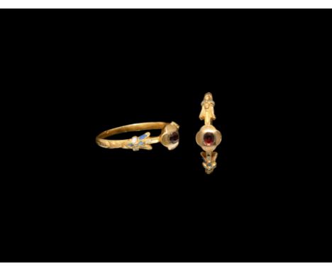 16th century AD. A slender gold finger ring with D-section hoop, foliage detailing to the shoulders with white and other enam