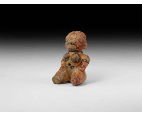 1st millennium AD. A glazed ceramic figurine of a nude female sitting with hands on her hips, painted linear ornament in red 