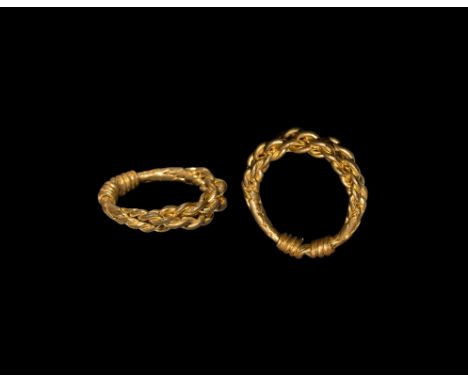 10th-12th century AD. A finger ring of braided gold wires, the tapering ends coiled around the shank.   7.93 grams, 26.52mm o