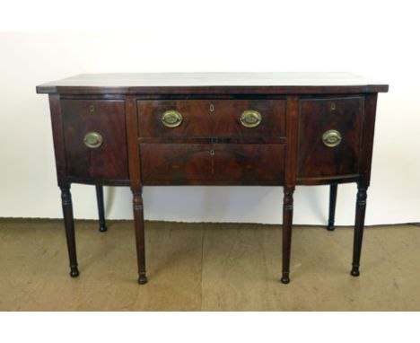 A Regency mahogany and ebony line inlaid bow fronted sideboard, the top over two central drawers flanked by one cupboard and 