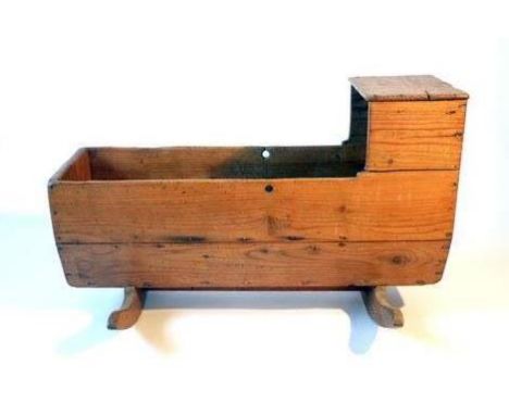 A 19th century pine and elm provincial child's rocking crib, the planked body on bow rockers, h. 60 cm, l. 95 cm, w. 62 cm CO