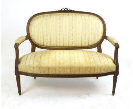 A Louis XV-style walnut framed two seater sofa in gold and cream upholstery on turned and fluted legs, h. 94 cm, w. 116 cm CO