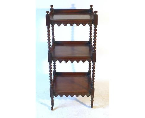 A Regency mahogany three tier whatnot, with bobbin turned supports and arched aprons to each shelf, with brass cup ceramic ca