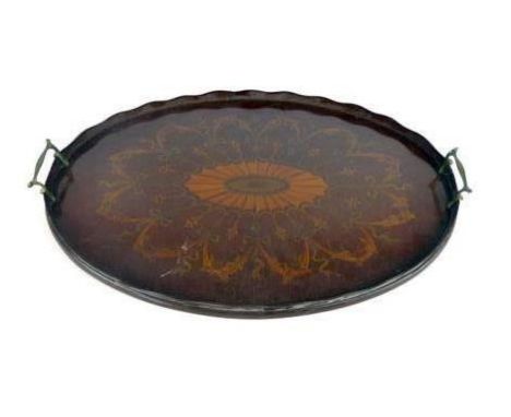 An Edwardian fiddle back mahogany and marquetry oval tray with wave gallery and brass handles, the sunburst central lozenge s