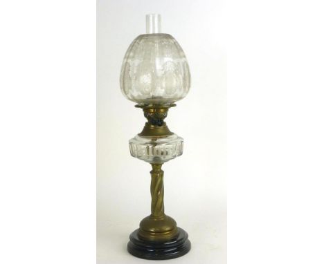 A Victorian oil lamp, the glass shade decorated with sprays and floral motifs on a brass spiral support and a tole base, h. 6