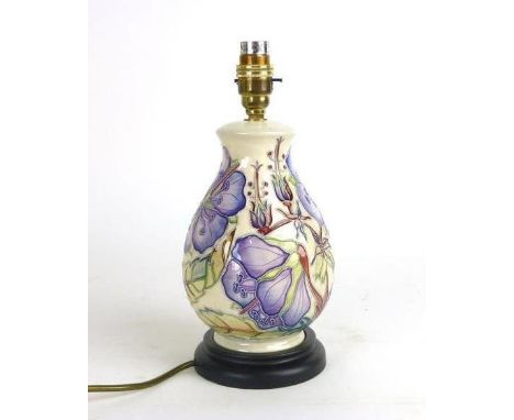 A Moorcroft table lamp of baluster form decorated in the 'Queens Choice' pattern, on a wooden plinth, h. 29 cm


