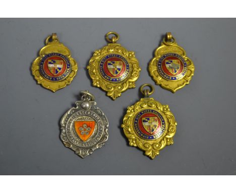 A silver and enamel Leicester Football Association fob; four gilt and enamel fobs, Birmingham