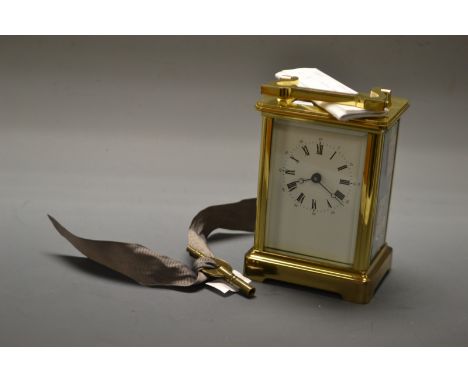 A lacquered brass five panel carriage clock, Roman numerals, white enamel dial, 11 cm high, 15cm over the handle
