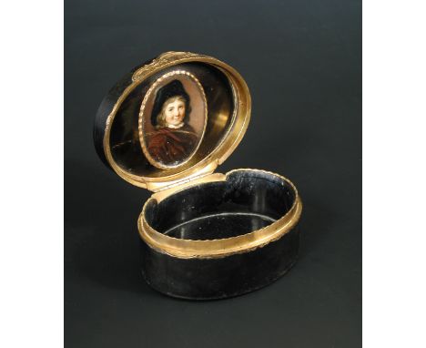 An 18th century oval horn box with gold mounts, the hinged cover inset with a watercolour portrait miniature on ivory of a yo