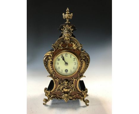 A 19th century gilt mounted mantel timepiece, the stained wood waisted case with urn finial and 7cm dial, Arabic numerals and