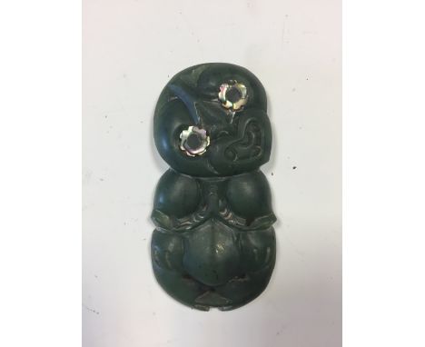 A Maori carved nephrite jade Hei Tiki, inset with mother-of-pearl eyes, pierced for suspension 8cm (3in)  