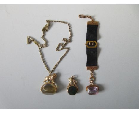 Two gold lion surmounted hardstone fob ornaments, another, and a chain necklace, the first a swivelling three sided pale yell