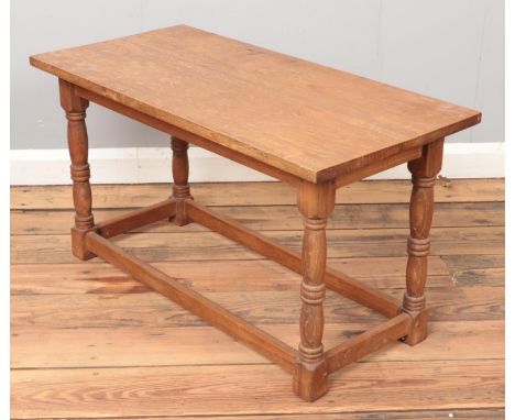 A light oak coffee table with turned supports. (47cm x 84cm x 41cm)  