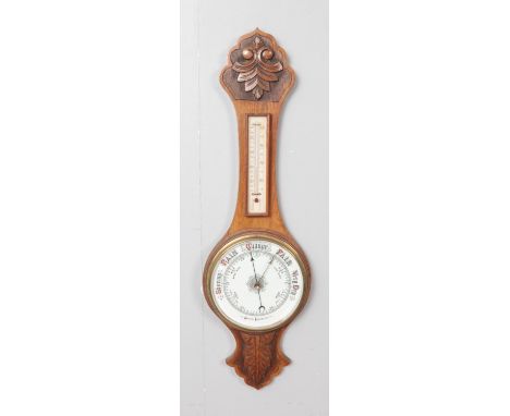 A carved oak banjo aneroid barometer, decorated with foliate design. 82cm high.  