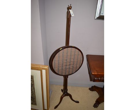 A 19th Century mahogany pole screen, the stand raised on tripod feet.