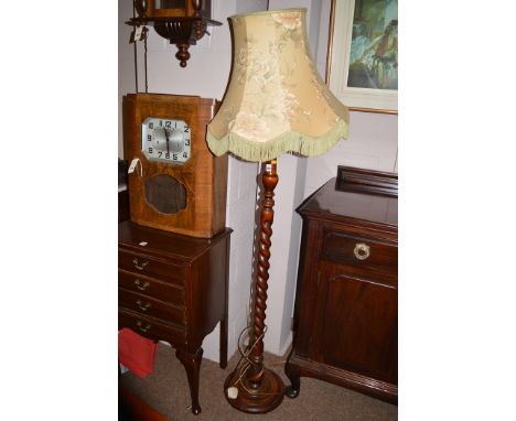 A 20th Century mahogany standard lamp with barley twist column, floral pattern shade and green tassels.