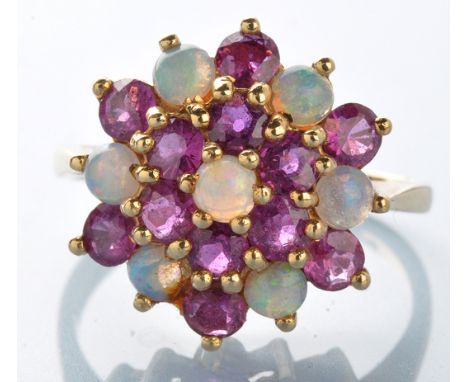 An ruby and opal cluster ring, set with circular oval cabochons surrounded by twelve circular facet cut rubies, on 9ct. yello