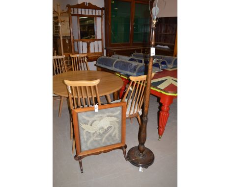 A stained oak standard lamp; and a walnut firescreen with mahogany base, embroidery to panel.  (2)