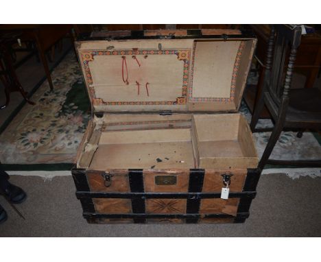 An early 20th Century leather bound trunk with metal and wood fitting opening to reveal compartments and tray.