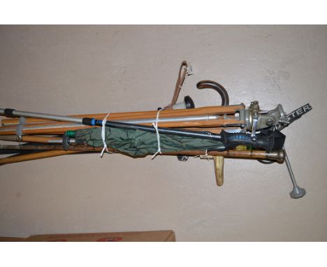 A metal and wood tripod; hiking sticks; umbrellas; and walking canes.